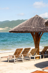 Beach umbrellas and chairs against blue ocean.