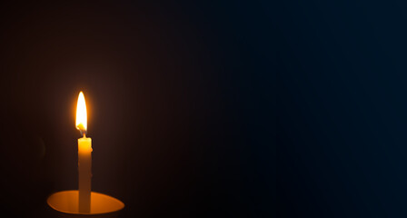 Burning candle on a dark background. Copy space for text.