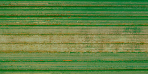 green metal roller shutter worn and oxidized by time and weather wall old steel door background...