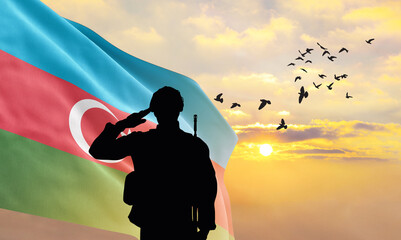Silhouette of a soldier with the Azerbaijan flag stands against the background of a sunset or...