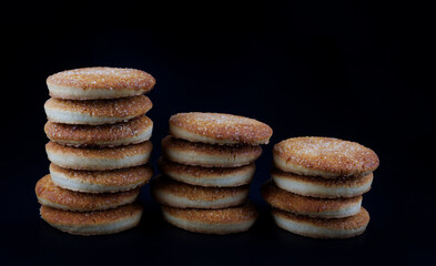 Beautiful round cookies on a black background. A few cookies. Three cookie towers.