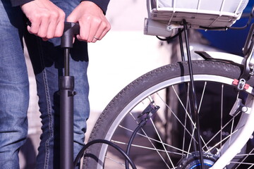 自転車のタイヤに空気を入れている手元の写真。自転車のメンテナンスや大切に扱っている様子をイメージ。