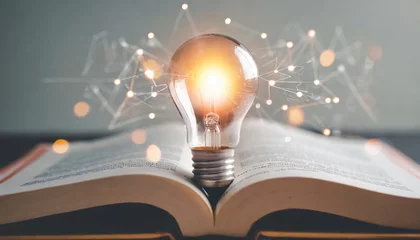 Fotobehang  light bulb glowing on book, idea of ​​inspiration from reading, innovation idea concept, Self learning or education knowledge and business studying concept © Marko
