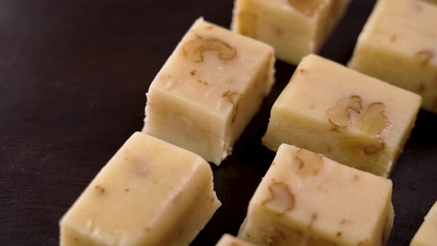 Sliced traditional Spanish Christmas Turron with almond and nougat on a wooden background. Rotation