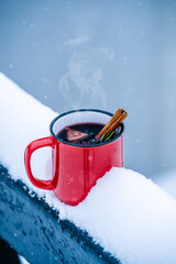 Mulled wine cup in winter forest. Winter hot drinks with aromatic spices of cinnamon, cardamom and...
