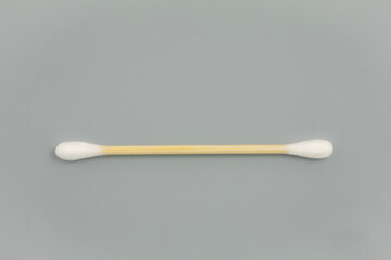 Closeup view of a csingle otton bamboo swab stick on light gray background