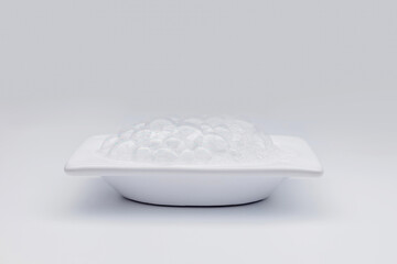 Clean modern ceramic bathtub. Soap bubbles. Bath foam. Isolated on white background.