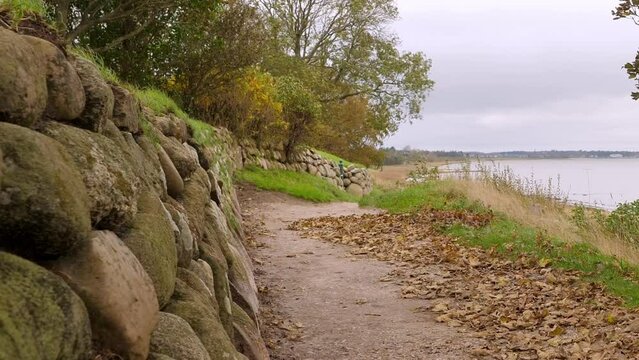 Panning shot over the north sea. Stone wall, small pathwy, autumn day at Sylt.