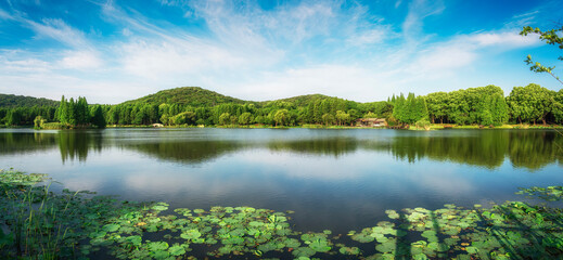 Beautiful city park with lake, trees and mountains