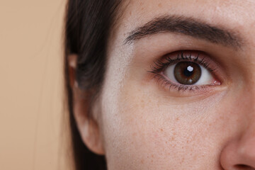 Closeup view of woman with beautiful hazel eyes on beige background