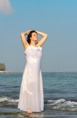 Fototapeta na wymiar Portrait of a beautiful woman in white dress on the beach