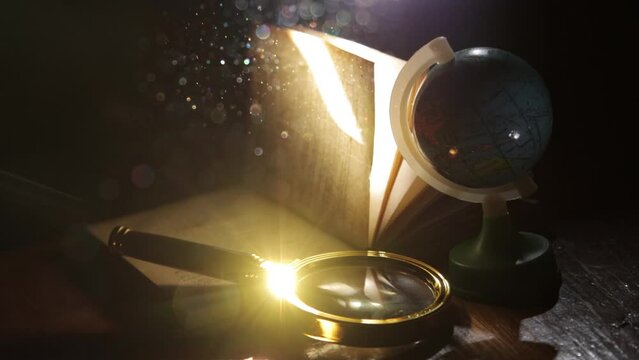 Open book with magnifying glass and globe