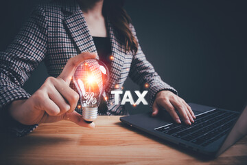 Businesswoman holding a light bulb tax icon for individuals and companies paying tax rates....