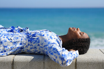 Relaxed black woman lying on the beach resting