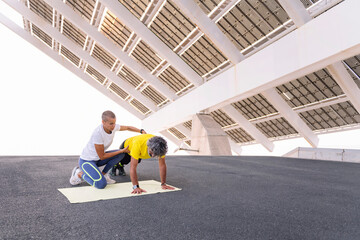 female personal trainer helping a senior sports man to do push ups correctly, concept of active and healthy lifestyle in middle age, copy space for text - obrazy, fototapety, plakaty