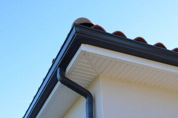 Gouttière aluminium gris anthracite sur la façade de la maison, descentes rectangulaires et lambris de sous-face