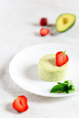 Vegan avocado panna cotta with fresh strawberries and mint in a plate.