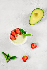 Vegan avocado panna cotta with fresh strawberries and mint.