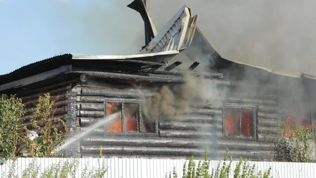 Firefighters extinguish a burning house