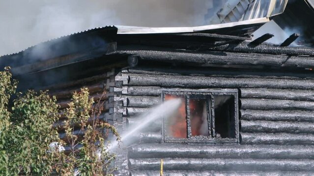 Firefighters extinguish a burning house