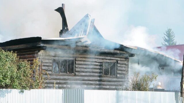 Firefighters extinguish a burning house