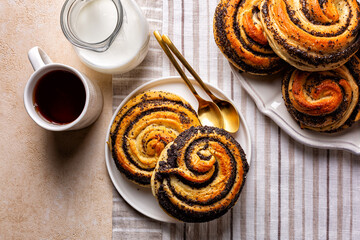 Table with baked homemade sweet poppy seeds buns, eastern European classic sweet yeast dough, swirl...