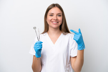 Dentist woman holding tools isolated on white background giving a thumbs up gesture