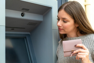 Young pretty blonde woman using an ATM