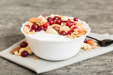Healthy breakfast food with granola, yogurt, fruits and nuts. Dessert parfait with dried fruits for breakfast