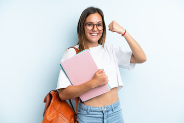 Young student woman isolated on blue background celebrating a victory