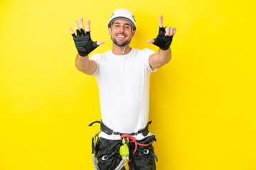 Young rock- climber man isolated on yellow background counting seven with fingers