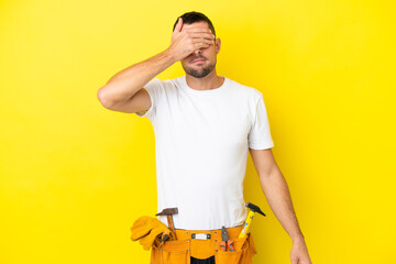 young electrician caucasian man isolated on yellow background covering eyes by hands. Do not want...
