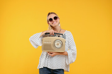 Portrait of happy hippie woman with retro radio receiver on yellow background - obrazy, fototapety, plakaty