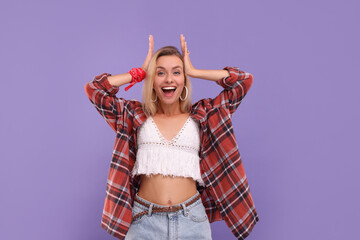 Portrait of excited hippie woman on purple background