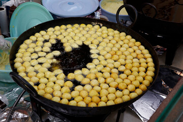arabic street food Logma or Legaimat (Lugaimat) preparation, is one of the most popular Emirati sweets in united arab emirates, UAE,served with dates syrup or honey