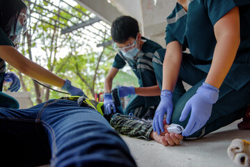 Rescuers are using equipment to check the body's pulse of worker at construction sites while unconscious and lying on the floor. Reading heartbeat with an oximeter. - obrazy, fototapety, plakaty