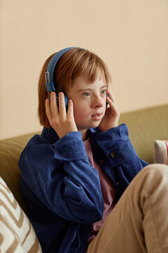 Teenager with Down syndrome listening to music using headphones