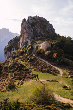 Young woman walking near mountain on sunny day