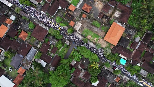 As procession moves, more and more people join it, and now we see huge, slow-moving crowd stretching along village street. Aerial shot of Melis day parade moving to beach