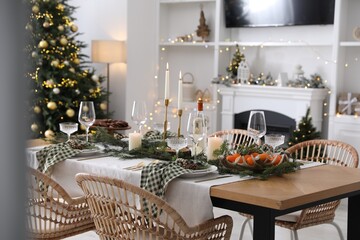 Christmas table setting with festive decor and dishware in living room