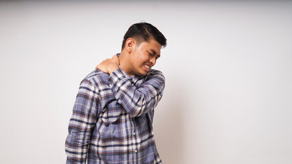 Gesture of young asian man suffering back pain on white background, studio shot