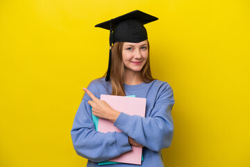 Young student Russian woman isolated on yellow background pointing to the side to present a product