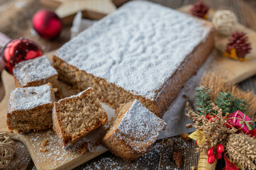 Christmas cake with hazelnuts on wooden rustic table background with xmas decoration