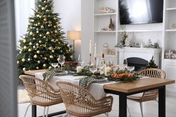 Christmas table setting with festive decor and dishware in living room