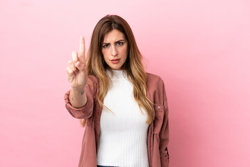 Caucasian woman isolated on pink background counting one with serious expression - obrazy, fototapety, plakaty