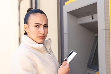 Young moroccan girl  at outdoors using an ATM