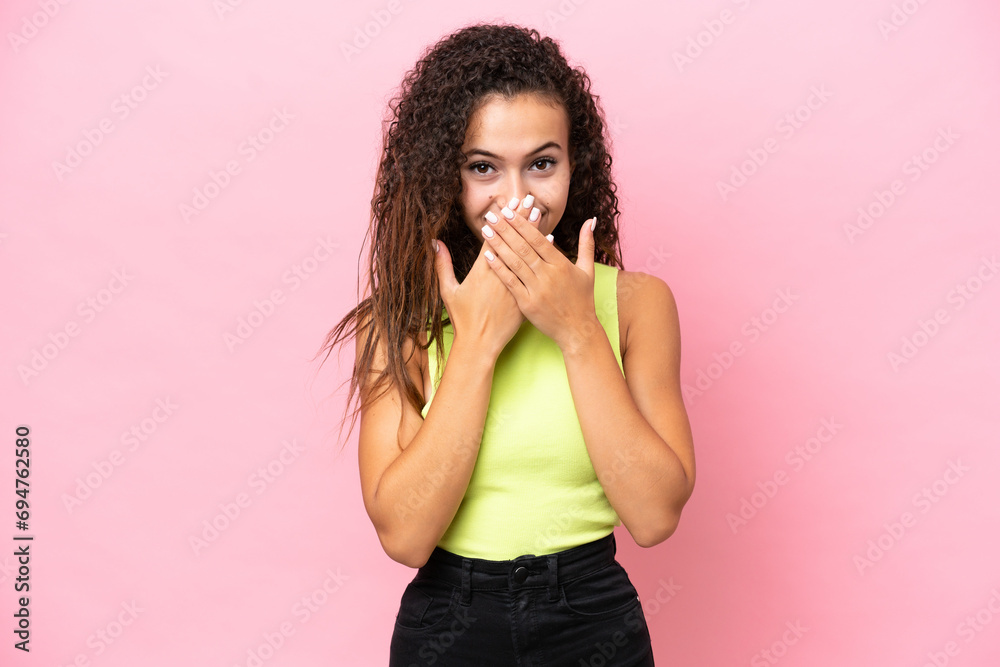 Wall mural young hispanic woman isolated on pink background happy and smiling covering mouth with hands