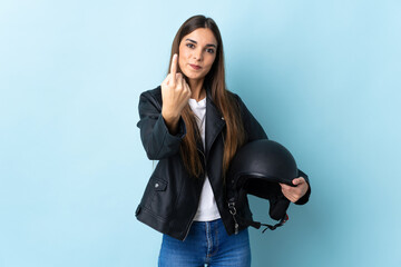 Young caucasian woman holding a motorcycle helmet isolated on blue background doing coming gesture