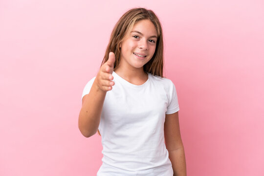Little caucasian girl isolated on pink background shaking hands for closing a good deal