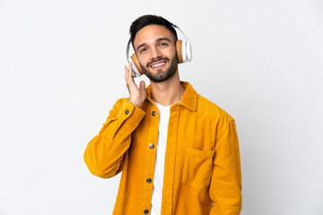 Young caucasian man isolated on white background listening music